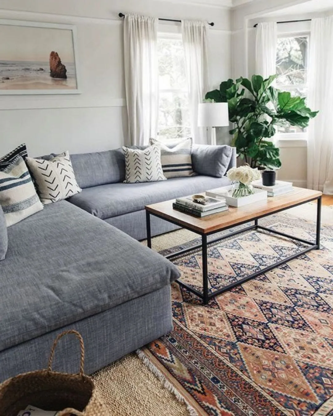 Bright, freshly cared-for living room with a gray sectional and patterned rug